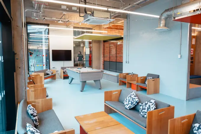 Bright social room in Beton House showing seating area and pool table.